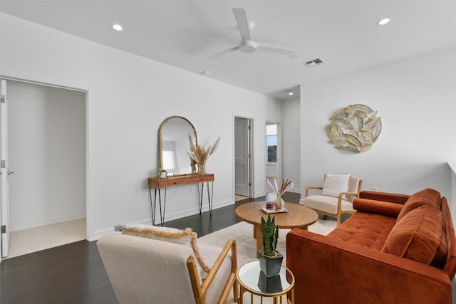 living room featuring dark wood-type flooring and ceiling fan