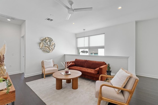 living room with dark wood-type flooring and ceiling fan