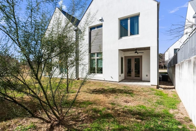 rear view of property featuring a yard, french doors, and ceiling fan