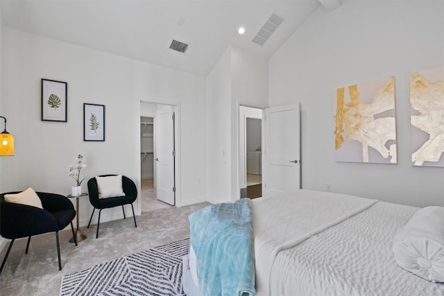 bedroom featuring high vaulted ceiling, a spacious closet, and light colored carpet