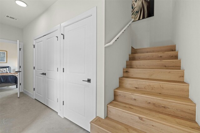 stairs featuring concrete flooring