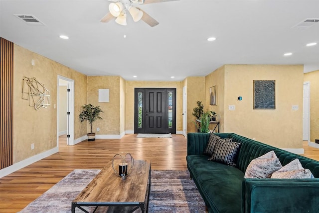 living room featuring light hardwood / wood-style flooring and ceiling fan