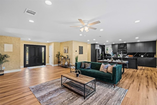 living room with ceiling fan and light hardwood / wood-style floors