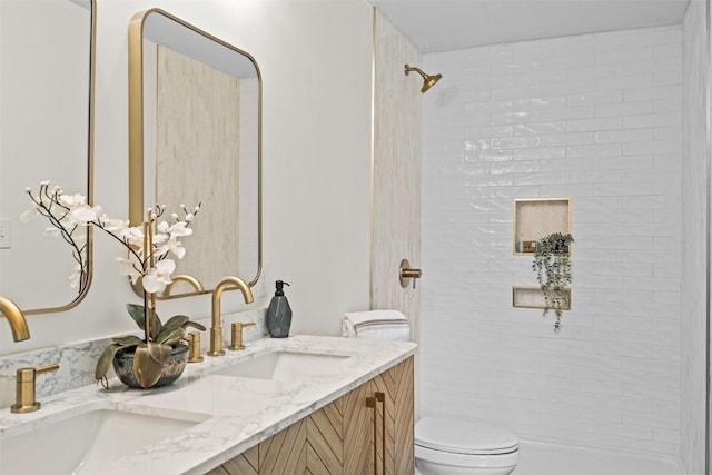 bathroom with vanity, toilet, and tiled shower