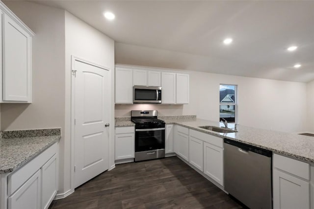 kitchen featuring white cabinetry, appliances with stainless steel finishes, sink, and kitchen peninsula