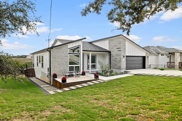 view of front facade featuring a garage, a front yard, and a patio