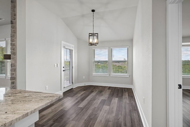 unfurnished dining area with a notable chandelier, dark wood-type flooring, and vaulted ceiling