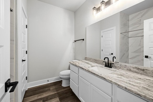 bathroom featuring tiled shower, vanity, toilet, and hardwood / wood-style floors