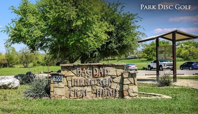 community / neighborhood sign featuring a yard