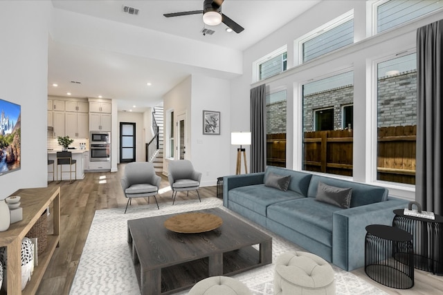 living room featuring light hardwood / wood-style flooring and ceiling fan