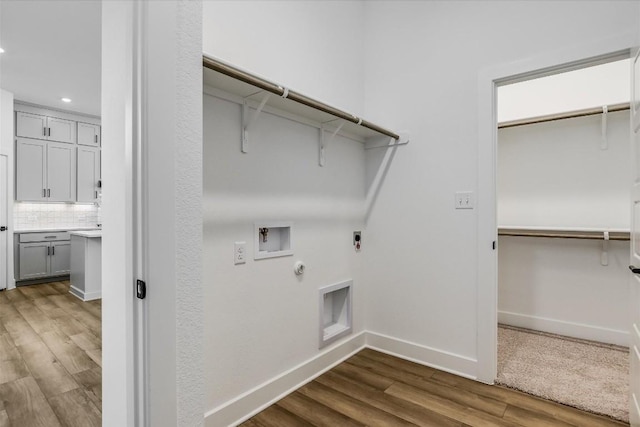 clothes washing area with hookup for a gas dryer, hardwood / wood-style flooring, electric dryer hookup, and hookup for a washing machine