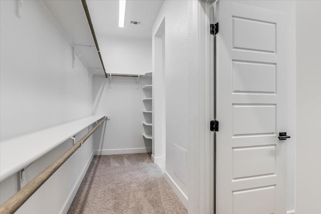 walk in closet featuring light colored carpet