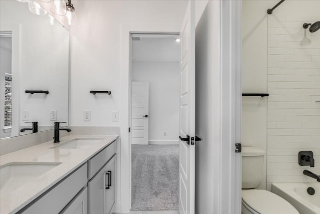 full bathroom with tiled shower / bath, vanity, and toilet