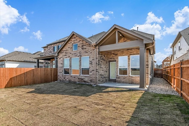 1349 S Brook Dr, Leander, TX 78641 - back of property with a fenced backyard, a patio, and brick siding