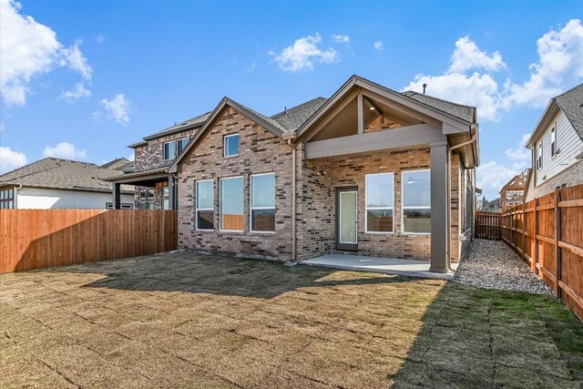 1349 S Brook Dr, Leander, TX 78641 - rear view of house featuring a fenced backyard, a patio area, and brick siding