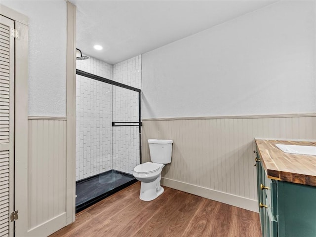 bathroom featuring vanity, toilet, a shower with shower door, and hardwood / wood-style floors