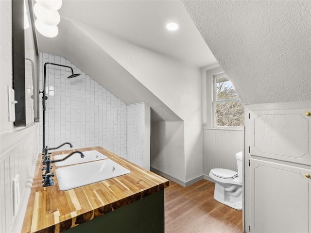 bathroom featuring walk in shower, toilet, a textured ceiling, vanity, and hardwood / wood-style floors