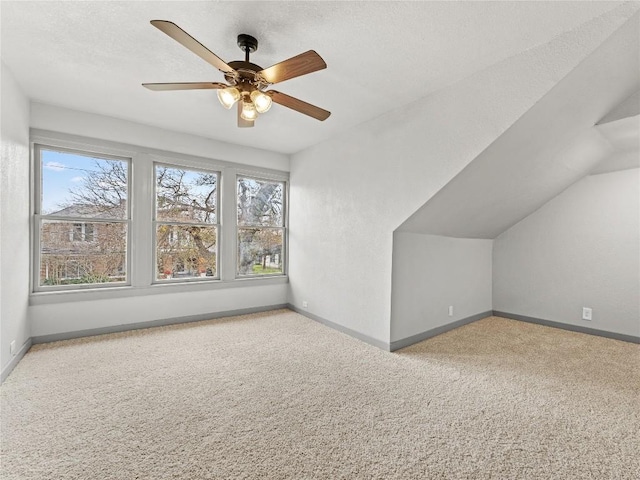 bonus room featuring lofted ceiling, a textured ceiling, light carpet, and a wealth of natural light