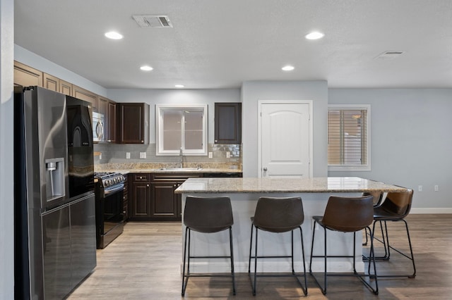 kitchen with sink, a breakfast bar area, a center island, and appliances with stainless steel finishes