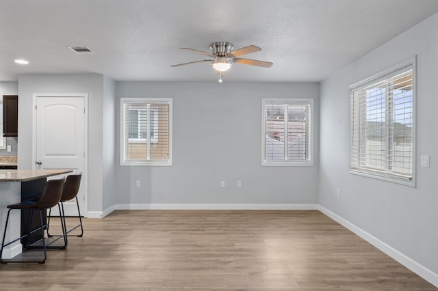 interior space with hardwood / wood-style flooring, ceiling fan, and a textured ceiling