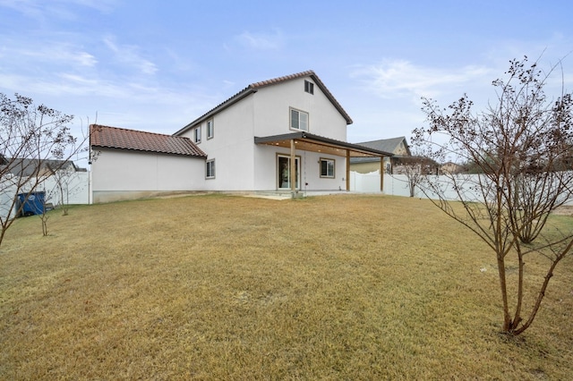 back of property with a yard and a patio