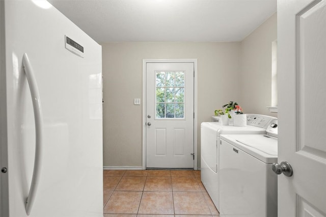 laundry area featuring separate washer and dryer and light tile patterned floors