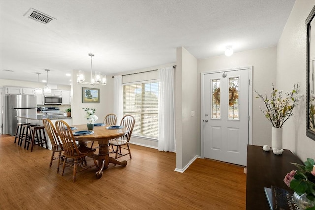 dining area with hardwood / wood-style flooring and a chandelier