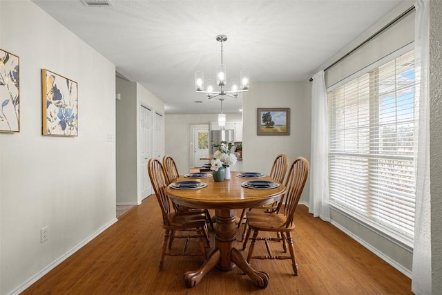 dining space featuring an inviting chandelier and light hardwood / wood-style flooring