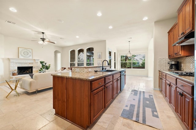 kitchen featuring appliances with stainless steel finishes, sink, decorative backsplash, hanging light fixtures, and a spacious island