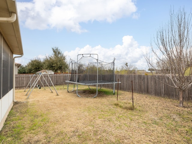 view of yard with a playground and a trampoline