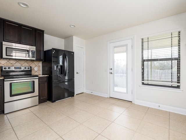 kitchen featuring dark brown cabinetry, appliances with stainless steel finishes, decorative backsplash, and light tile patterned floors