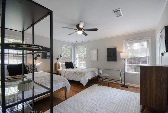 bedroom with wood-type flooring, ornamental molding, and ceiling fan