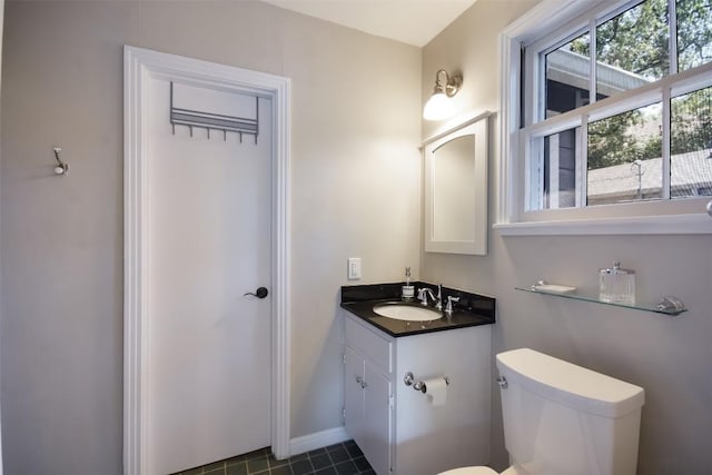 bathroom featuring vanity, a wealth of natural light, and toilet