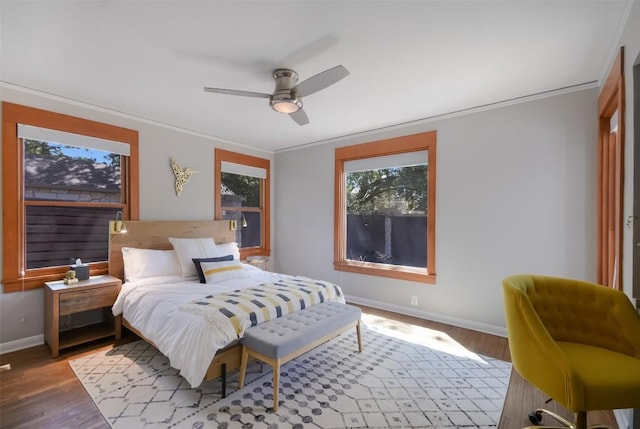 bedroom featuring crown molding, wood-type flooring, and ceiling fan