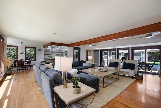 living room featuring ceiling fan, beam ceiling, and light hardwood / wood-style flooring