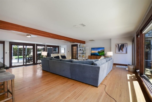 living room featuring beam ceiling and light hardwood / wood-style flooring