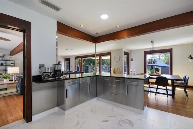 kitchen with beamed ceiling, plenty of natural light, and kitchen peninsula