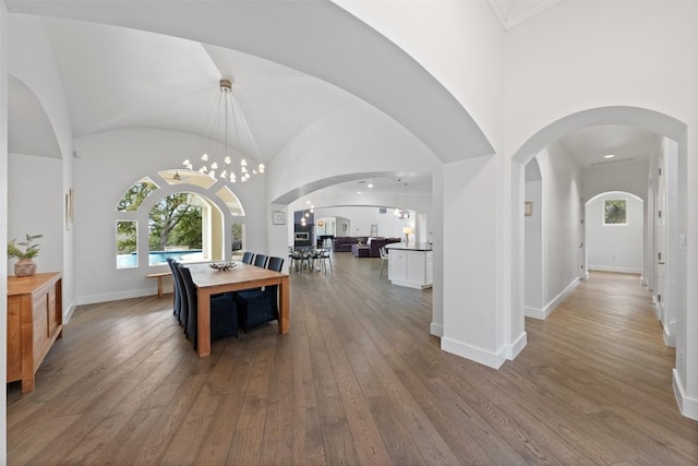 dining area with high vaulted ceiling, plenty of natural light, and hardwood / wood-style floors