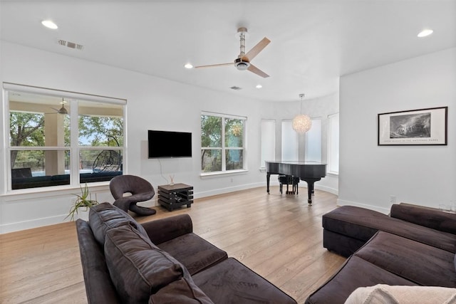 living room featuring ceiling fan and light hardwood / wood-style floors