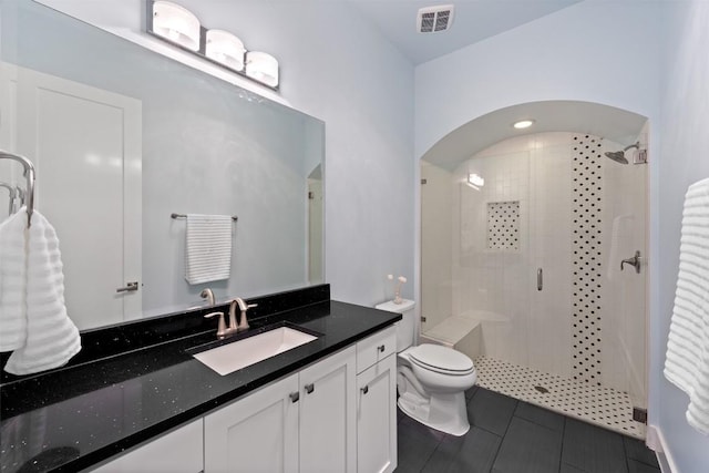 bathroom with vanity, toilet, tile patterned flooring, and a shower with door