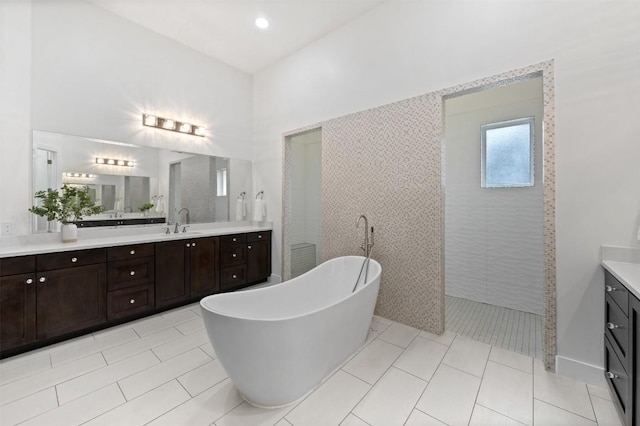 bathroom featuring tile patterned flooring, vanity, and plus walk in shower