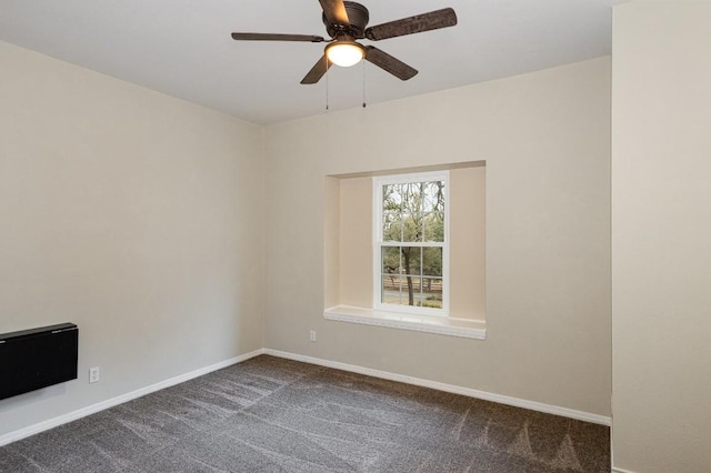 unfurnished room featuring baseboards, dark carpet, and ceiling fan