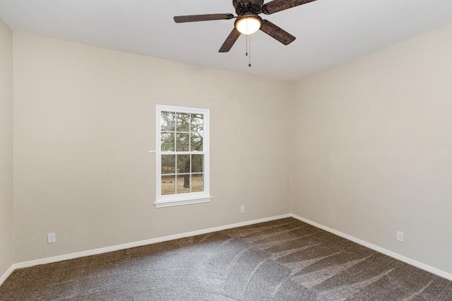 unfurnished room with a ceiling fan, dark carpet, and baseboards