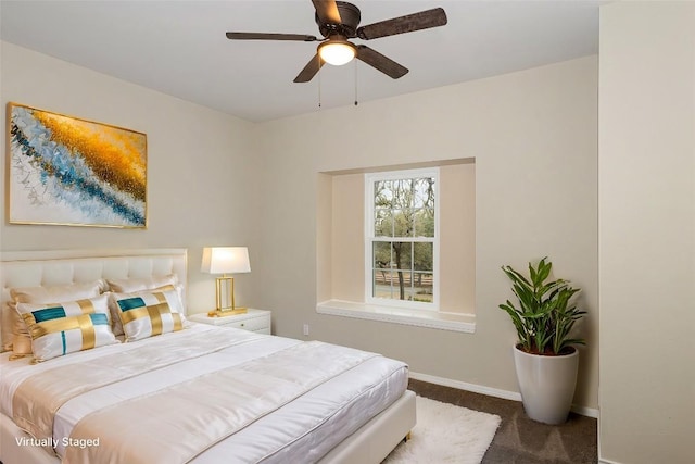 carpeted bedroom with ceiling fan and baseboards