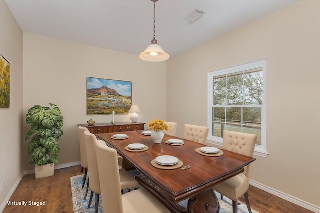 dining area featuring wood finished floors, visible vents, and baseboards