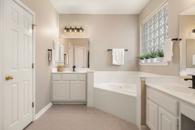 bathroom with a tub to relax in, tile patterned flooring, and vanity