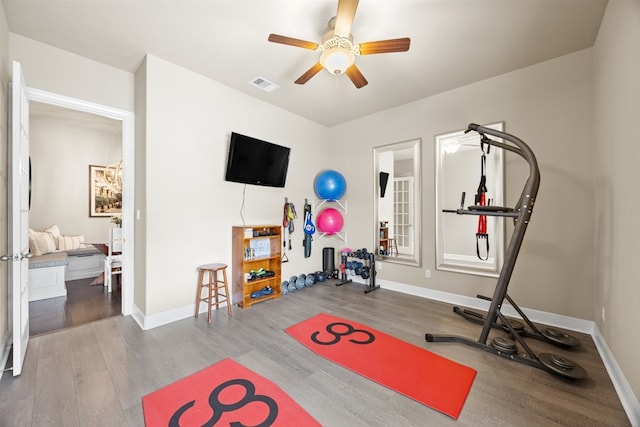 exercise area with visible vents, ceiling fan, baseboards, and wood finished floors