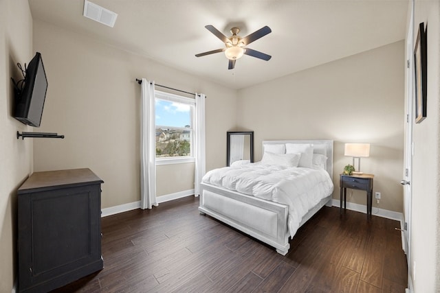 bedroom featuring a ceiling fan, dark wood finished floors, visible vents, and baseboards