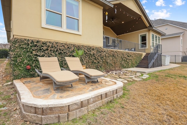 view of yard featuring a patio area, fence, stairway, and a ceiling fan