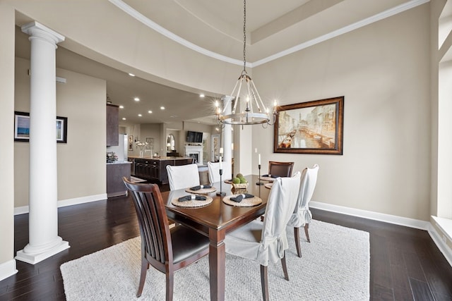 dining area with ornate columns, a notable chandelier, baseboards, and dark wood-style flooring